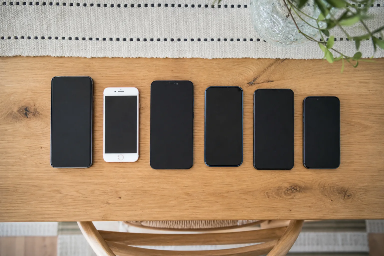 Flera mobiltelefoner uppradade på ett träbord